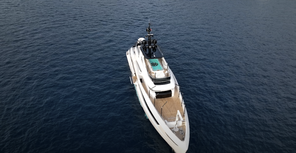 Aerial top view photo of a white yacht floating in the water